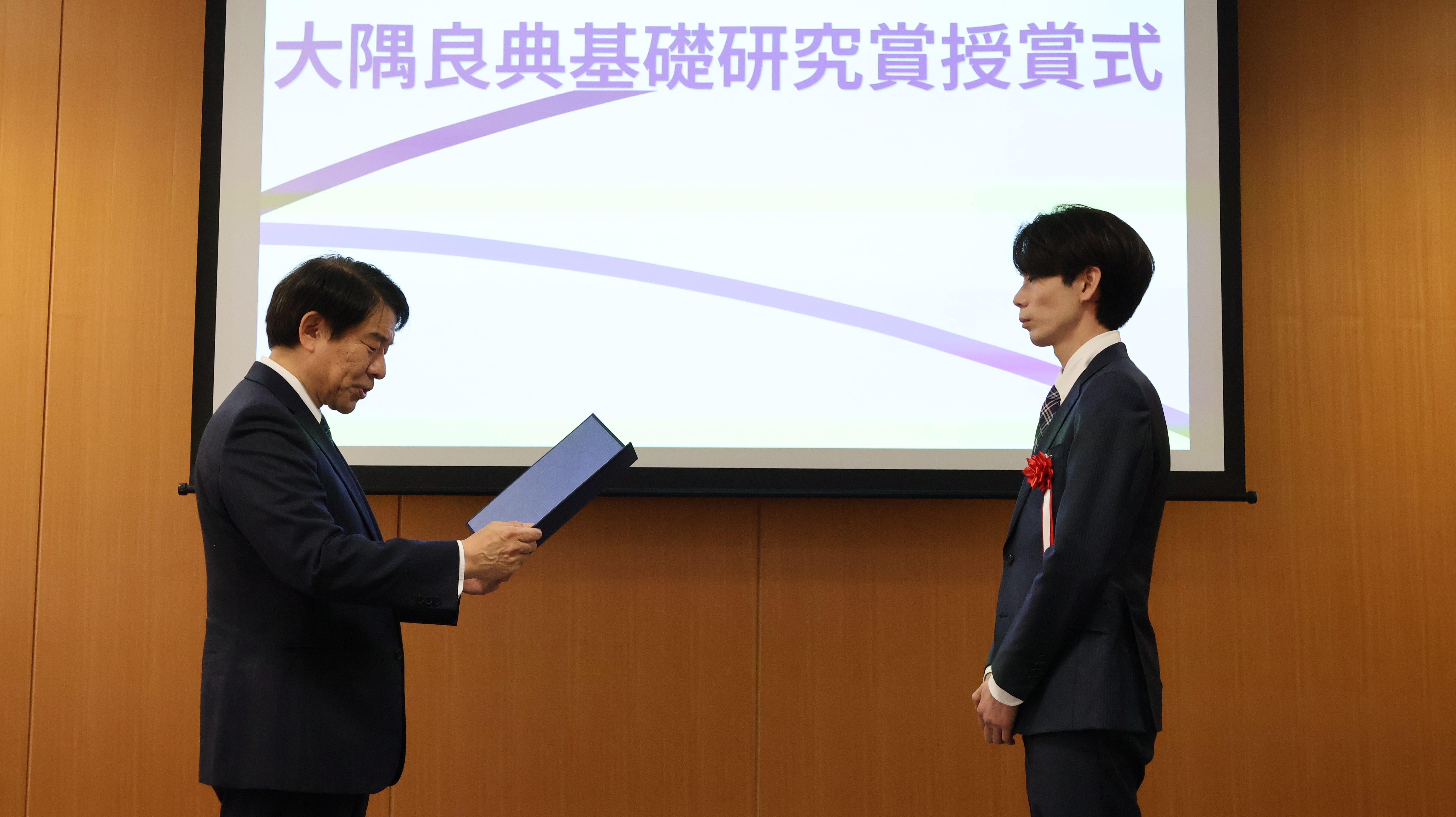 Assistant Professor Nogami receiving a certificate of commendation from the president and Chief Executive Officer